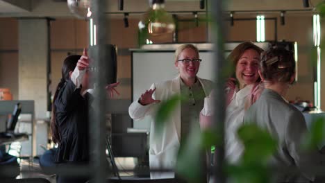 Side-view-of-a-group-of-happy-businesswomen-in-business-clothes-dancing-while-celebrating-their-Victory-and-success-while-working-in-a-modern-office