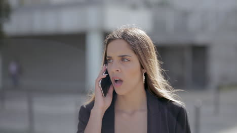 stressed young woman talking by cell phone outdoor