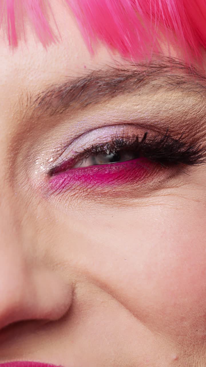 Vertical video: Macro shot of positive woman with glamour colorful eye makeup