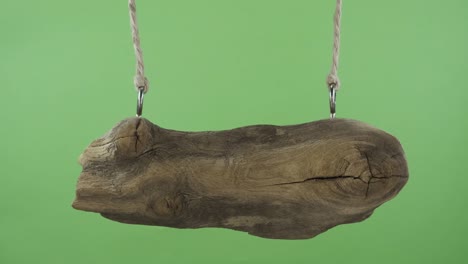 an old sign made from a board, swinging suspended from ropes. isolated on green screen.