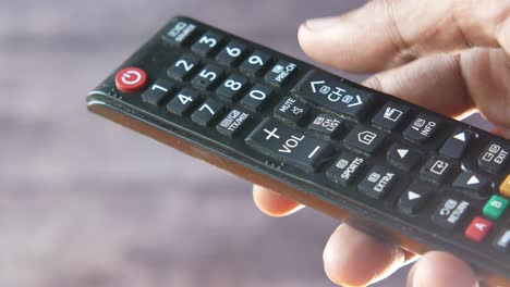 mano con un control remoto de televisión