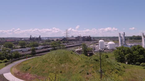 factories blowing off smoke and steam into a blue sky with white clouds