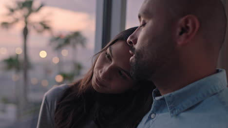 pareja feliz abrazándose mirando por la ventana relajándose en casa compartiendo una conexión íntima disfrutando de la hermosa vista al atardecer planeando el futuro juntos
