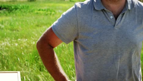 confident beekeeper standing with hands on hip