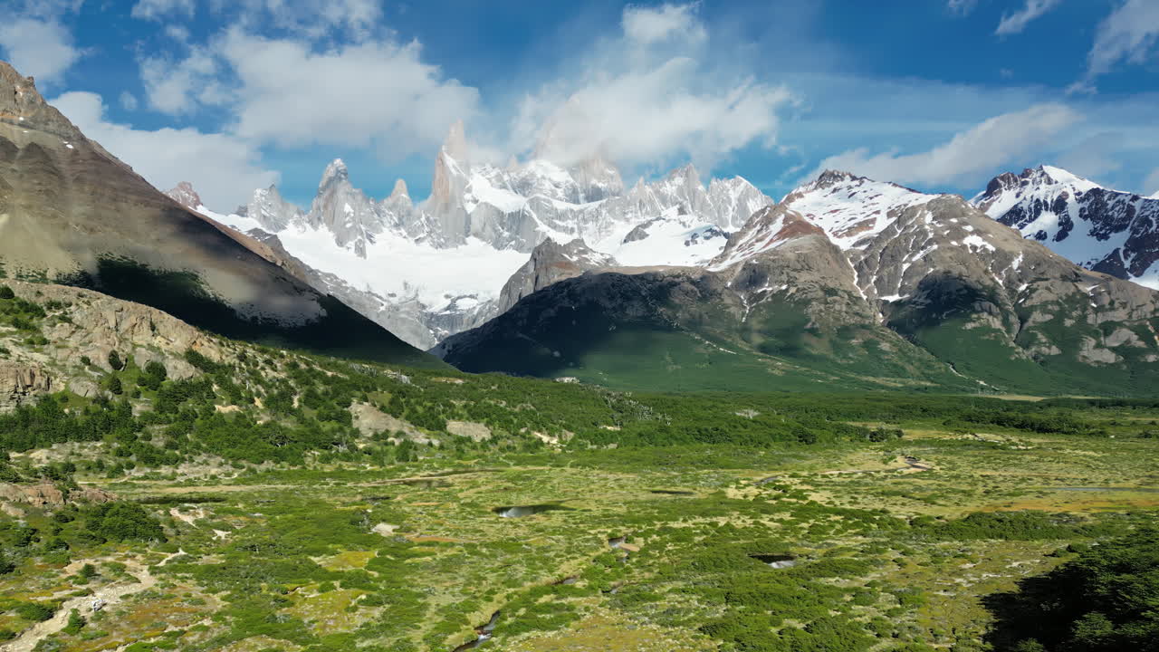 Aerial drone view of Mount Fitz Roy and surrounding peaks under a clear blue sky
