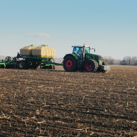 Steadicam-Pan-Shot:-Tractors-With-Seeders-Sow-Wheat-On-The-Field-In-Early-Spring