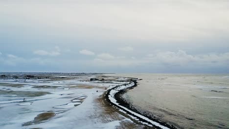 slow flight over frozen sandgerdi, iceland golf course and coast