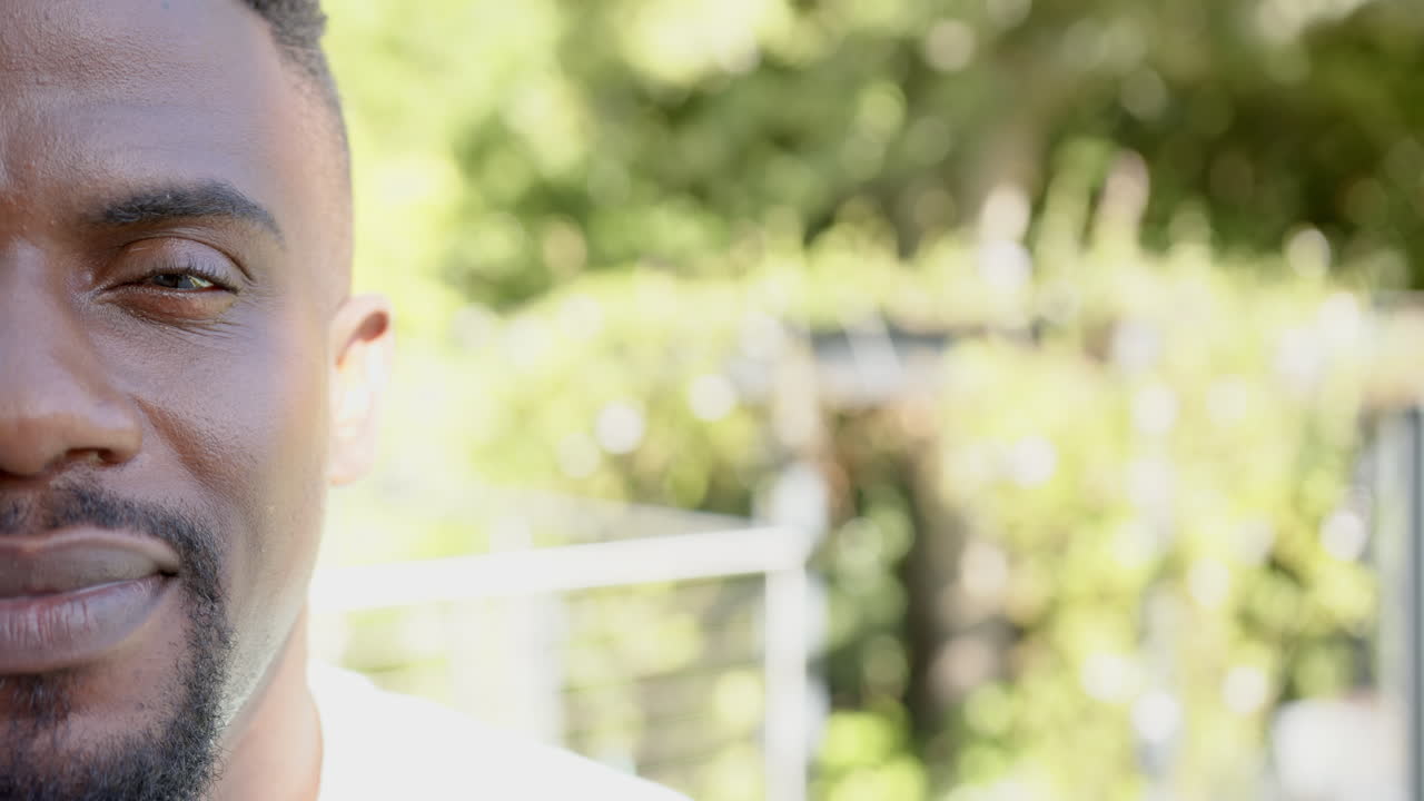 Uomo sorridente all'aperto che si gode una giornata di sole, primo piano del viso con sfondo sfocato, spazio per il testo.