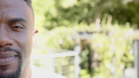smiling man outdoors enjoying sunny day, close-up of face with blurred background, copy space