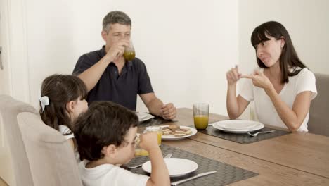 Family-couple-and-two-kids-drinking-fresh-orange-juice