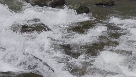 close-up of water cascading over the rocks of goa rang reng waterfall on bali island