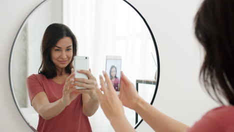 woman taking selfie in front of mirror