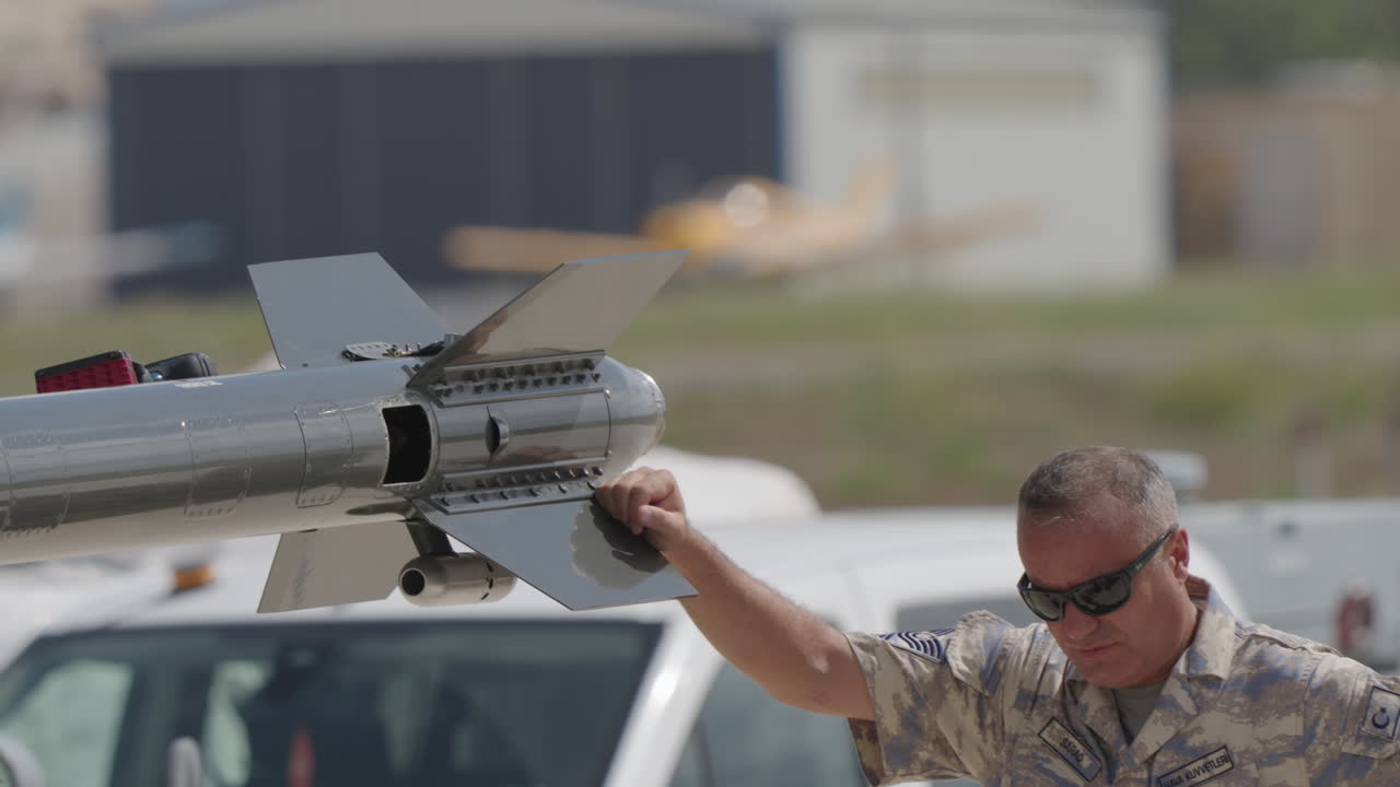 Military Officer Standing Near a Missile on an Airbase
