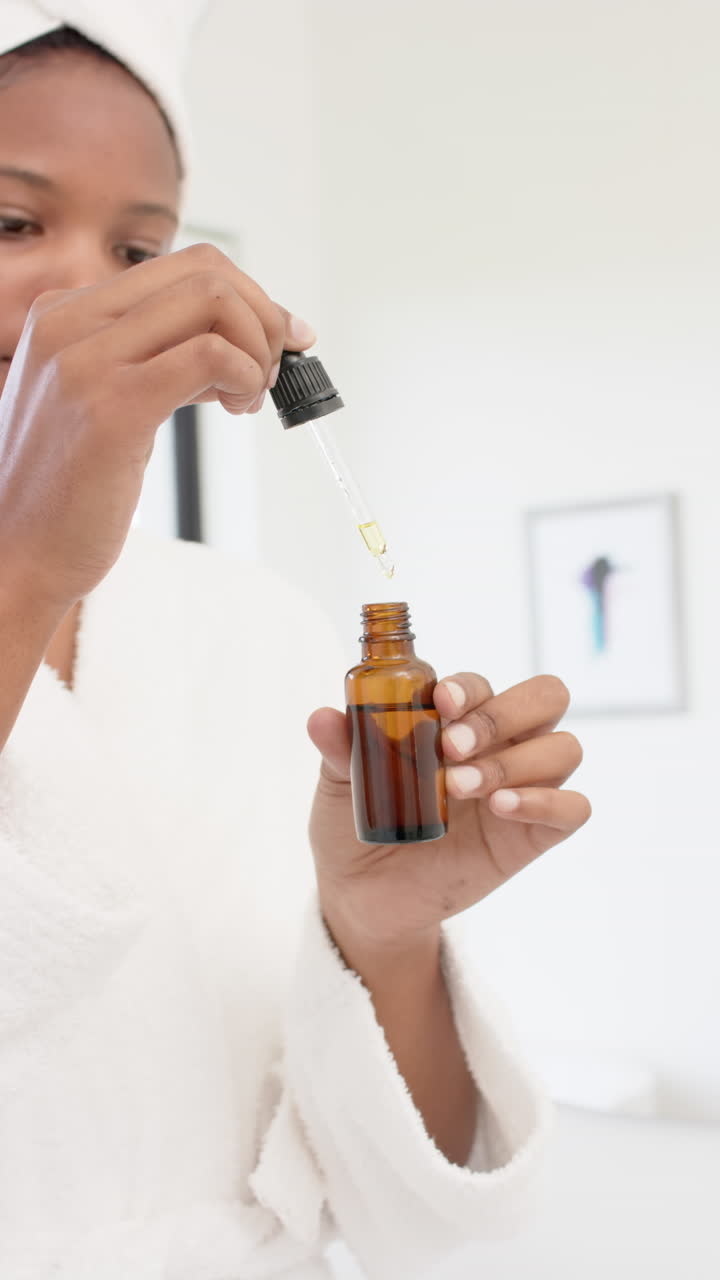 Vertical video of african american applying oil, slow motion