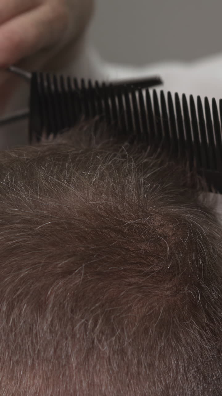 Close-up of Barber Cutting Short Hair with Scissors and Comb