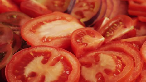cutting colorful organic tomatoes on wooden desk . mix tomatoes background, several varieties of sliced tomatoes top view. different assorted colorful tomatoes, heirloom, cherry, rose, beefsteak, cocktail, grape, purple.