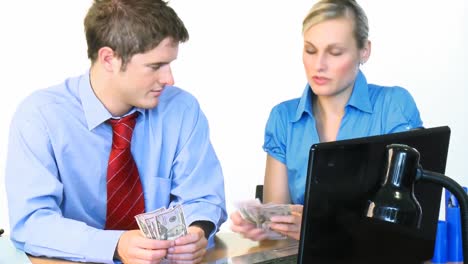 businessman and businesswoman counting dollars