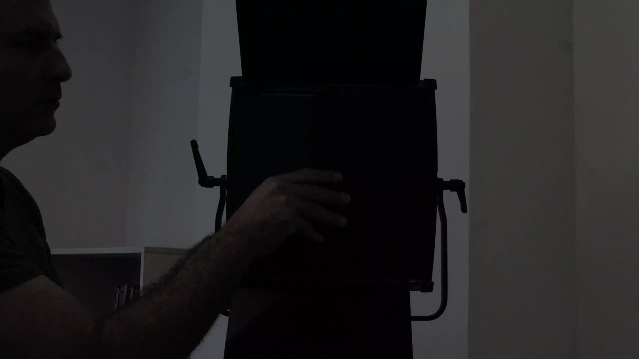 cineasta ajustando el equipo de iluminación del estudio preparándose para filmar