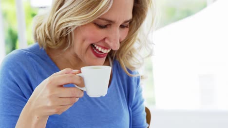 Smiling-woman-having-a-cup-of-tea-at-home
