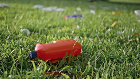 plastic bottle lying discarded on grass highlighting pollution problem closeup