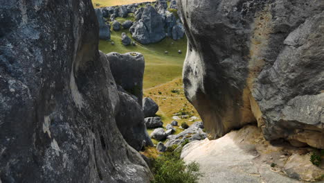 tilt up shot showing many big boulders in green fields during sunny day