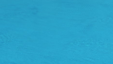 superficie de agua en la piscina con gotas de lluvia