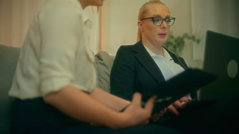 two women work on a laptop during business meeting