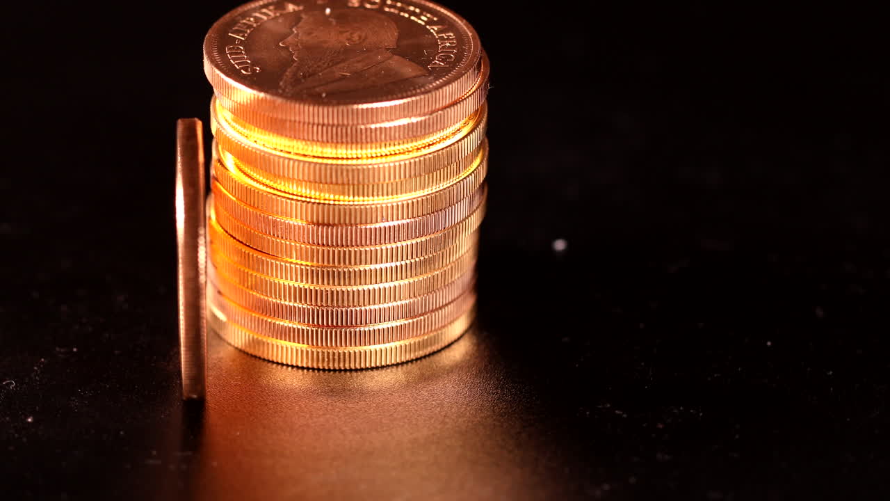 junto a un montón de monedas de oro se encuentra una moneda de oro krugerrand