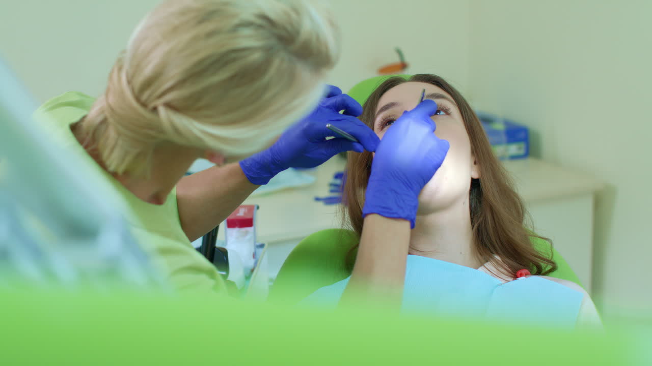 el dentista pone un tampón de algodón en la boca abierta del paciente. proceso de tratamiento dental
