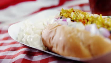 hot dog with bowl of sauce served on napkin cloth