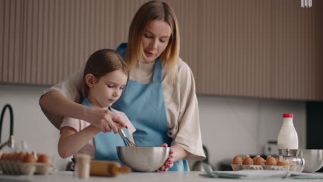 Mutter-Bringt-Ihrer-Kleinen-Tochter-Das-Kochen-Bei-Und-Hilft-Dabei,-Sahne-Für-Kuchen-Zu-Schlagen,-Mutter-Und-Kind,-Mädchen