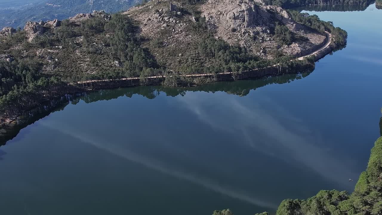 Snoet flod spejler træer og klipper på Korsika på en solskinsdag