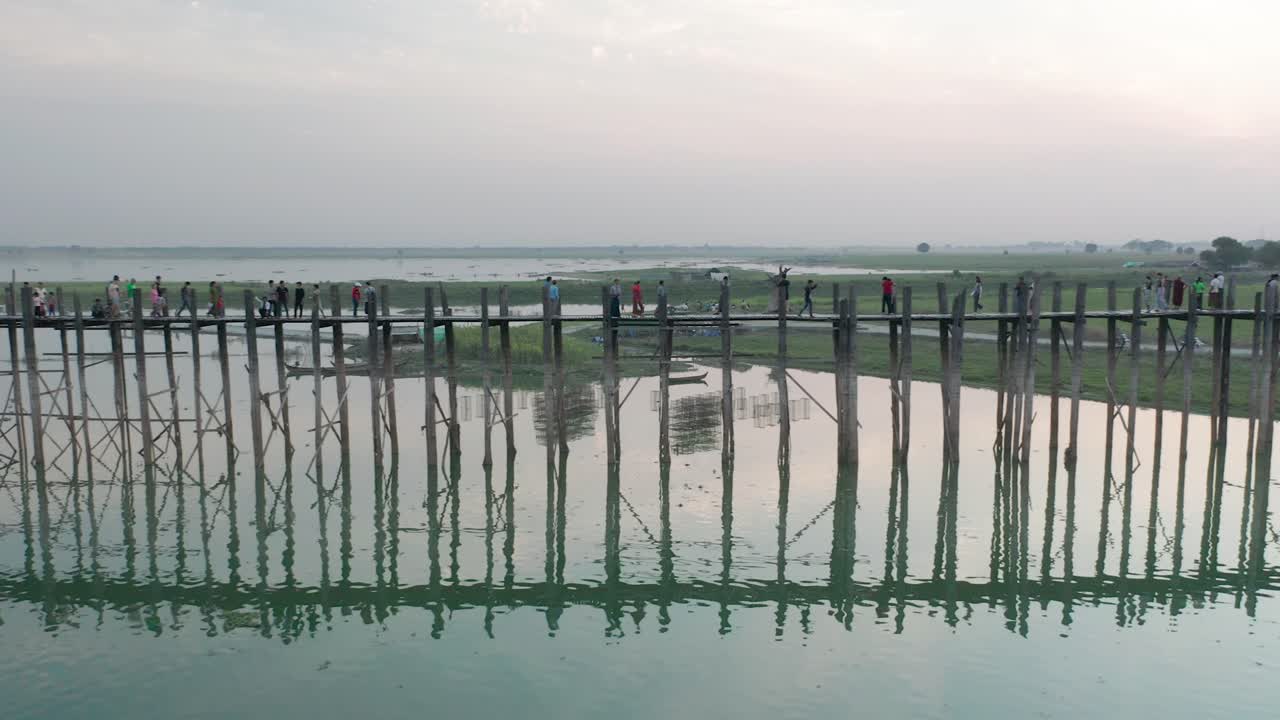 vista lateral del famoso puente de madera de teca u bein durante la puesta de sol, camión a la izquierda