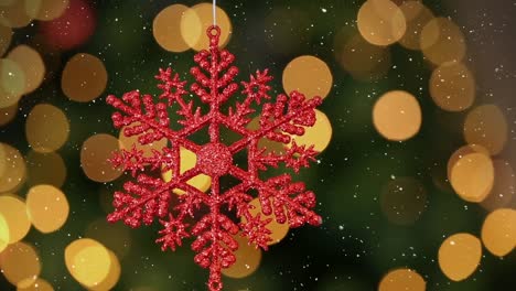 Animation-of-snow-falling-over-red-christmas-bauble-decoration