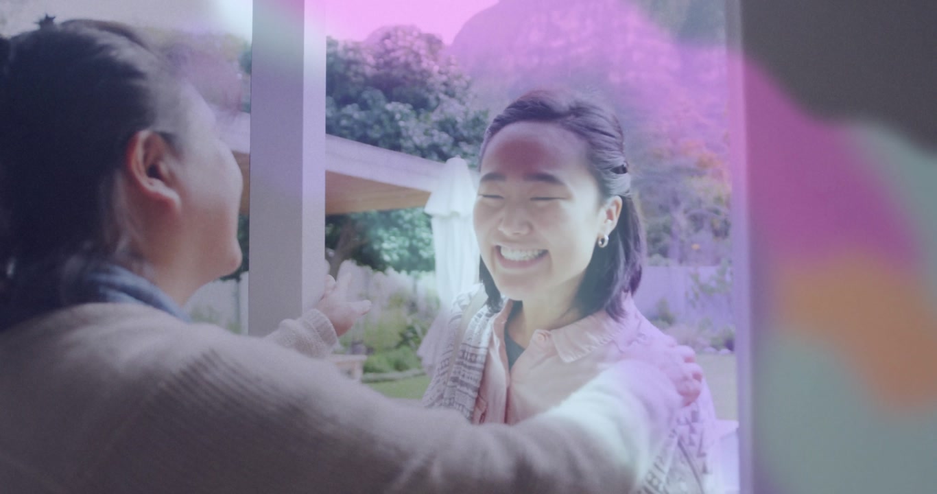 Daughter welcoming father at doorway, showcasing real estate marketing with animated plant icons