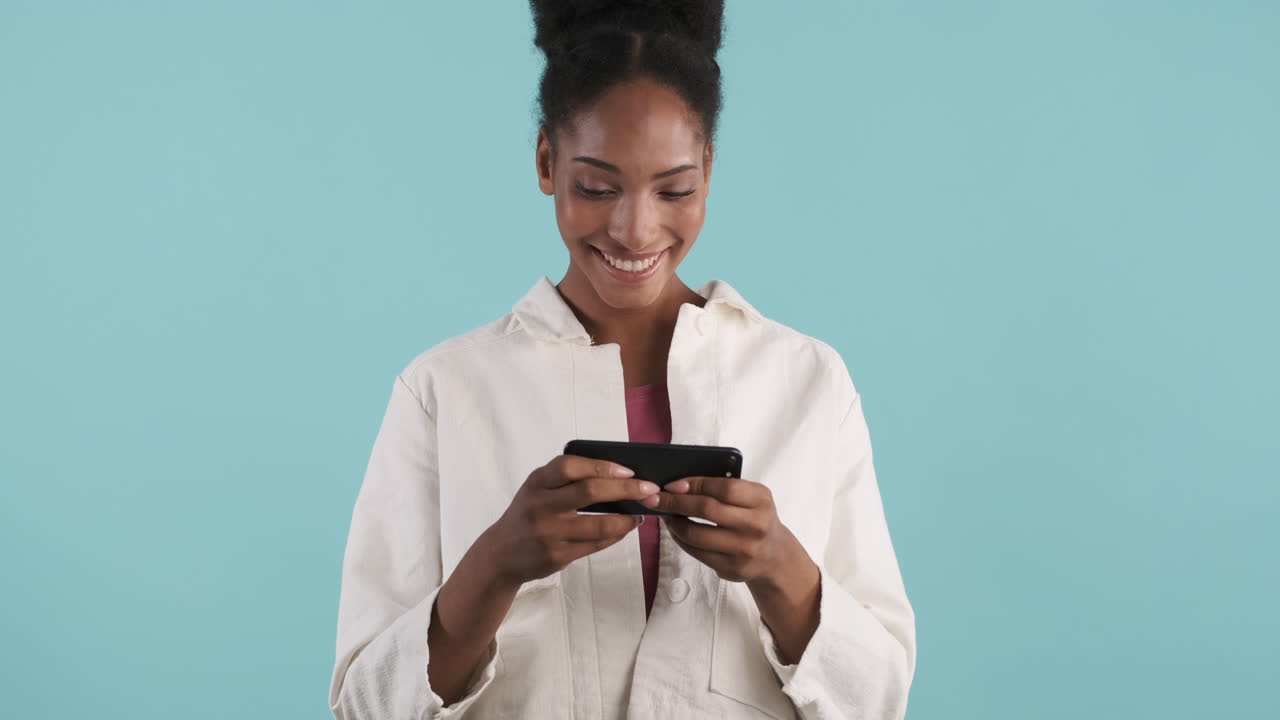 Smiling woman playing videogame on phone