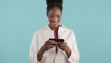 lächelnde frau spielt videospiel am telefon