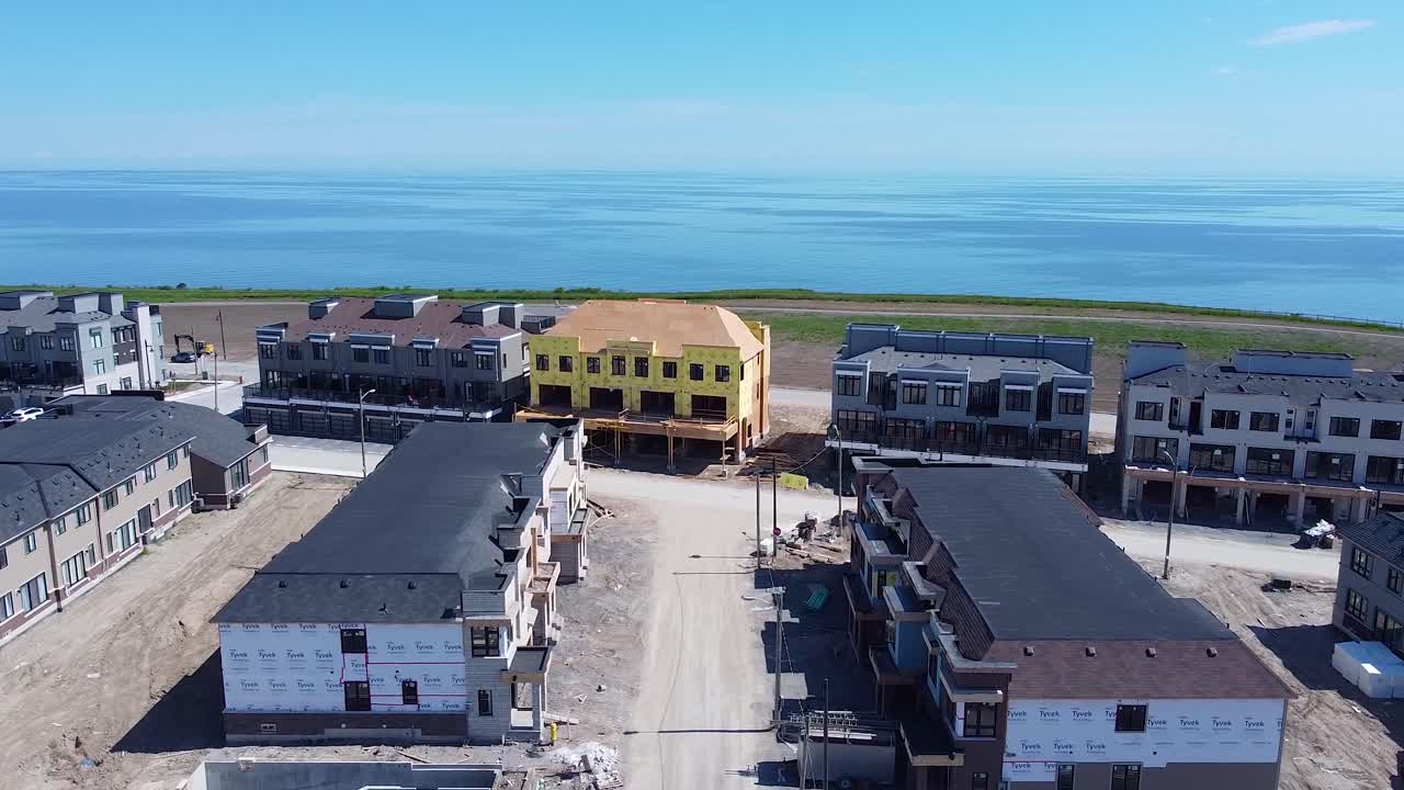 casas nuevas en construcción con cimientos de hormigón, marcos de madera y techos en el desarrollo de viviendas cerca del lago