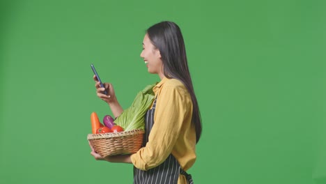 woman using smartphone to scan vegetables in basket