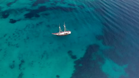 viejo velero de madera que llega a una bahía para echar el ancla