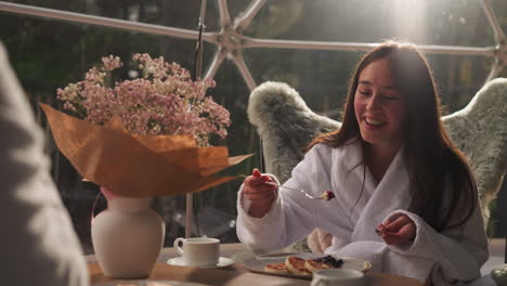 girl enjoying breakfast in a glass dome