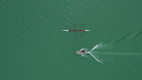 aerial close to high shot over a rowing team with a coach on a boat lake france