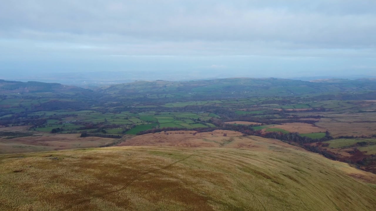 Luftfoto højt oppe i Brecon Beacons med vandrestier nedenfor og landbrugsmarker i baggrunden 4K