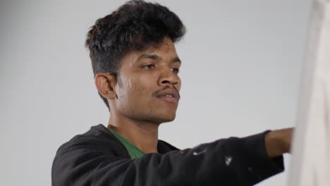 Young Male Artist Painting on Canvas