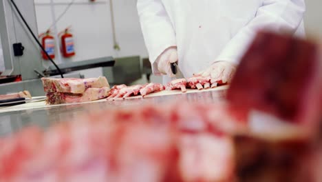 carnicero que corta carne cruda