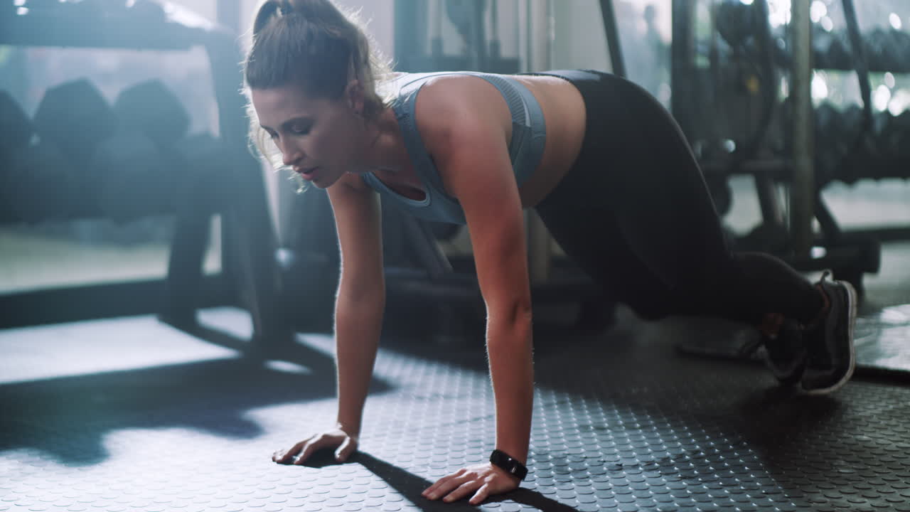 mujer haciendo flexiones en un gimnasio