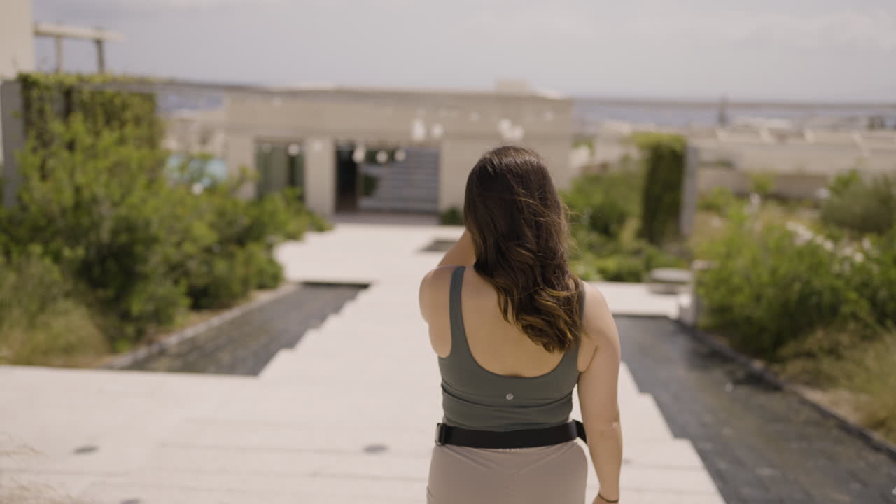 Slow motion bokeh shot of a female tourist walking through the streets of Santorini