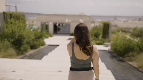 slow motion bokeh shot of a female tourist walking through the streets of santorini