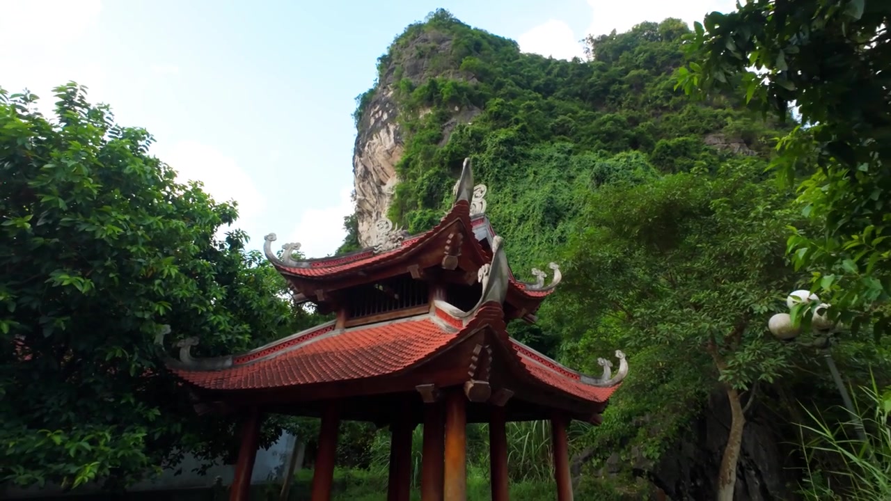 Den Voi-templet i Ninh Binh, Vietnam, der viser traditionel vietnamesisk religiøs arkitektur omgivet af frodigt grønt, bjerge og fredfyldt landskabsudsigt.