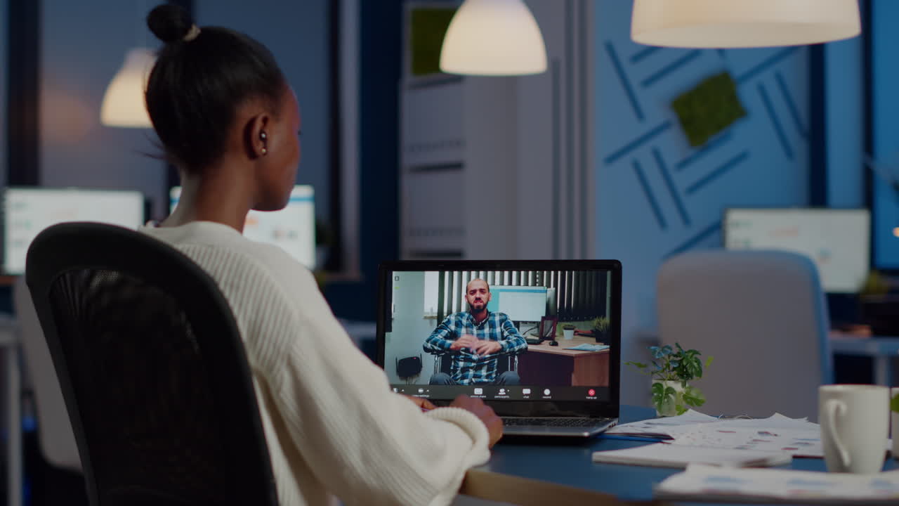 African businesswoman having corporate meeting with remotely paralyzed man